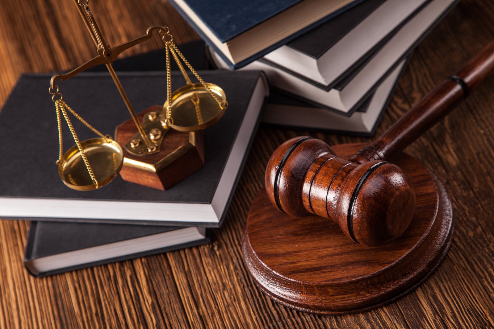 Legal books, scales and a judge gavel on a desk